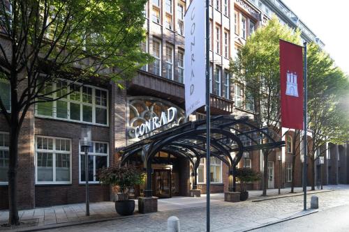 a building with a sign in front of it at Conrad Hamburg in Hamburg