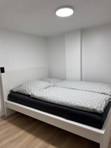 a bed in a room with a white wall at Comfy House Privé in Erftstadt