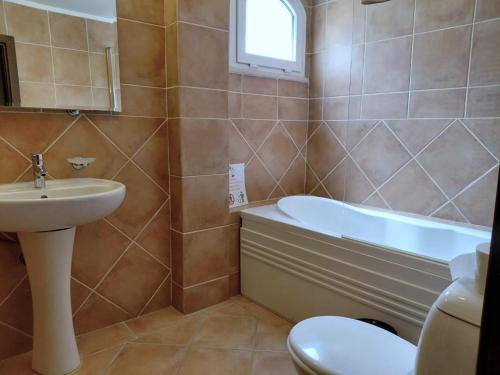 a bathroom with a sink and a tub and a toilet at Villa Sakura in Kyrenia