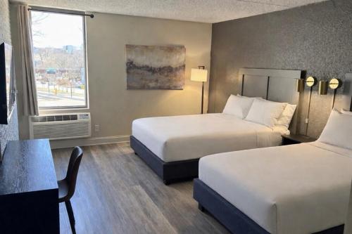 a hotel room with two beds and a window at Hotel Arlington in Arlington