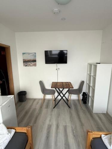 a living room with a table and chairs and a tv at K 357 - Low budget Hotel in Ratekau bei Lübeck in Ratekau