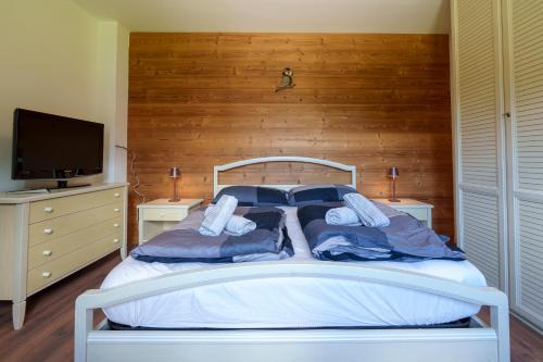 a white bed with two pillows and a television at Affittacamere ai 4 venti in Arta Terme