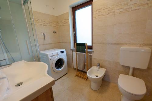 a bathroom with a washing machine and a washer at Affittacamere ai 4 venti in Arta Terme