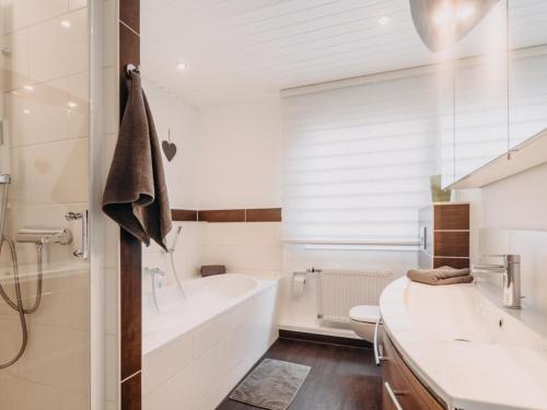 a bathroom with a tub and a toilet and a sink at Hillside Braunlage in Braunlage
