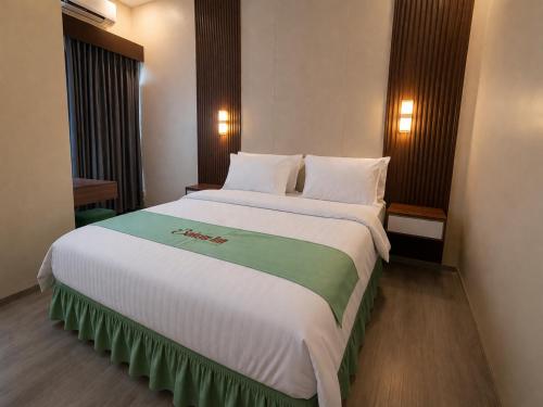 a bedroom with a large bed in a room at Bakom Inn Syariah in Bogor