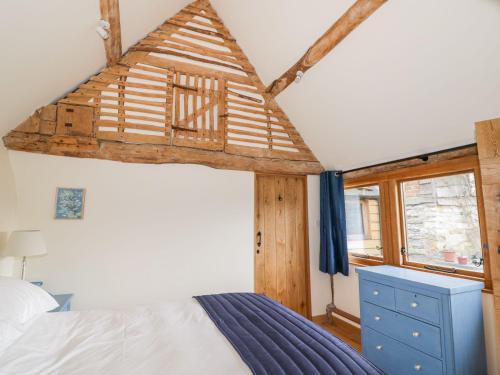 ein Schlafzimmer mit einem Bett und einem Holzdach in der Unterkunft Ryepiece in Stratford-upon-Avon