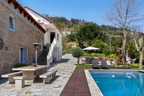 a villa with a swimming pool next to a house at Quinta do Rio Douro - Turismo Rural in Paços de Gaiolo