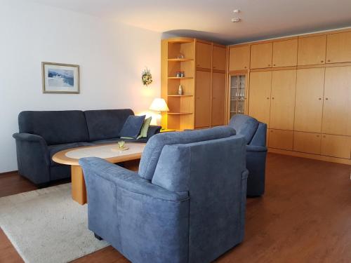 a living room with two blue chairs and a table at FeWo Krüger 17 in Dahme