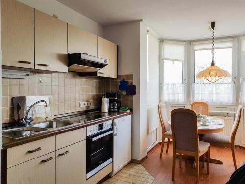 a kitchen with a sink and a table with chairs at FeWo Krüger 17 in Dahme