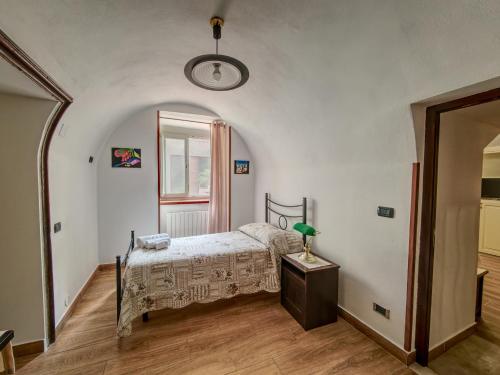 a bedroom with a bed and a table with a lamp at Dammuso Nuzzarè in Syracuse