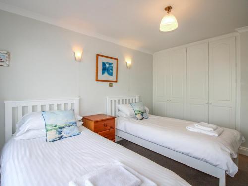 two beds in a room with white walls at 7 Thurlestone Rock in Kingsbridge