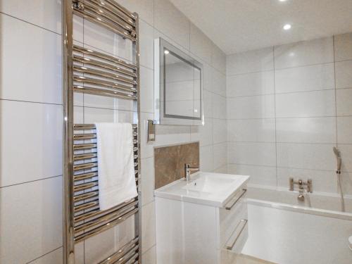 a white bathroom with a sink and a mirror at 7 Thurlestone Rock in Kingsbridge