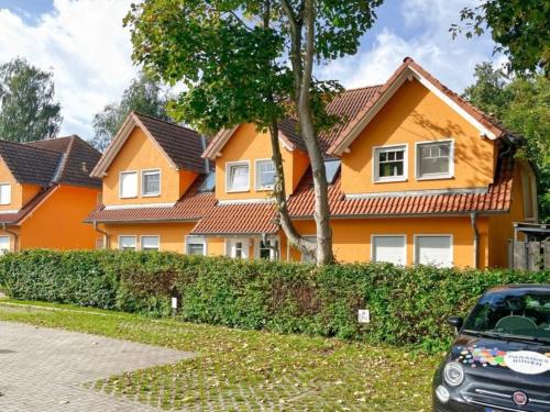 an orange house with a car parked in front at Rügenglück in Breege