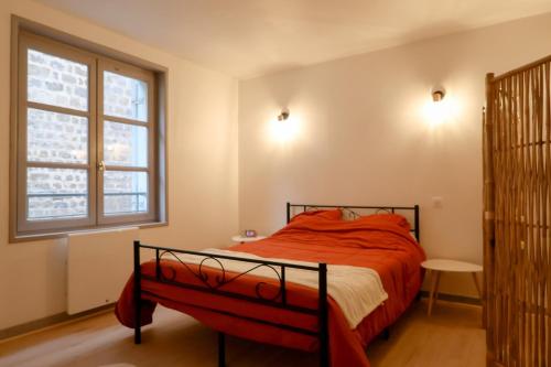 a bedroom with a bed with red sheets and a window at Le Saint Regis - Hyper centre. in Le Puy-en-Velay