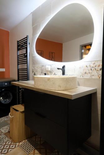 a bathroom with a sink and a mirror at Le Saint Regis - Hyper centre. in Le Puy-en-Velay