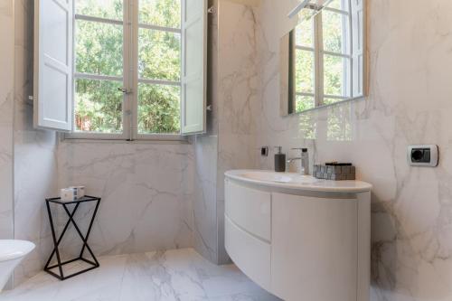 a white bathroom with a sink and a toilet at Villa Guinigi Dimora di Epoca Exclusive Residence & Pool in Lucca