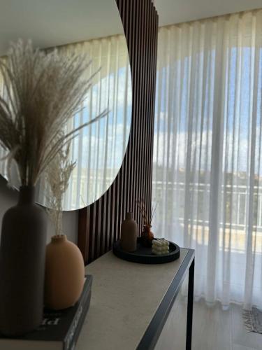 a mirror on a table in a room with a window at Cliff Edge Apartment in Xaghra in Taʼ Bullara