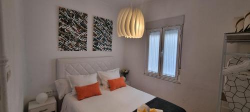 a bedroom with a bed with orange pillows and a window at Casa Roman SPORT in León