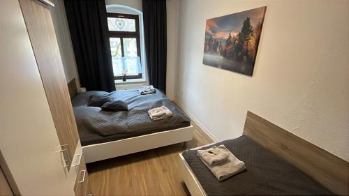 a small bedroom with a bed and a window at FeWo Blick zum Lulatsch in Chemnitz