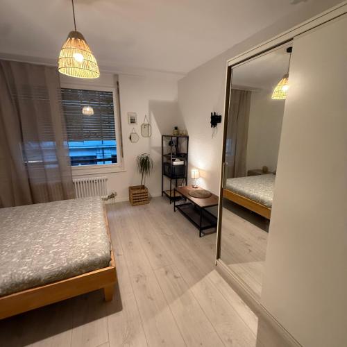 a bedroom with a mirror and a bed and a table at Appt Lausanne Gare - Totti in Lausanne