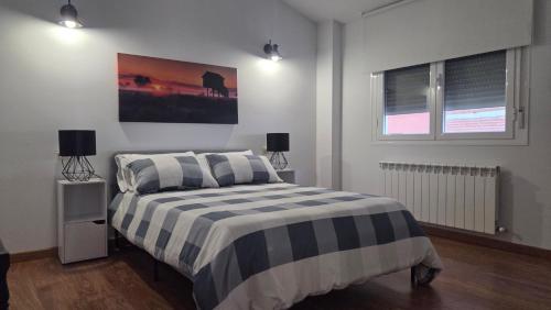 a bedroom with a bed with a black and white striped blanket at Ático Vista La Sierra in Jarandilla de la Vera