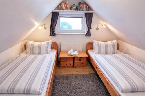 two beds in a small room with a window at Ferienhaus Ostseebrise Usedom im Grünen familienfreundlich ruhig Parkplatz Terrasse Kamin in Karlshagen