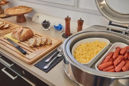 a kitchen counter with eggs and sausage on a cutting board at Appart'hôtel Odalys City - Antibes Olympe in Antibes