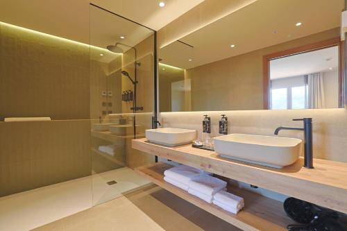 un bagno con due lavandini e una doccia di Hotel Fonsispa a Bisaurri