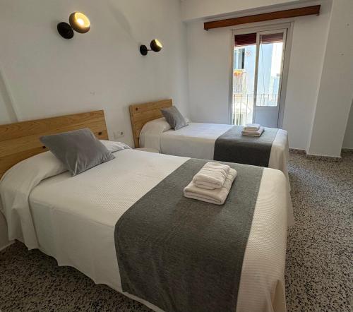 a bedroom with two beds with towels on them at Hostal Paco Marbella in Marbella