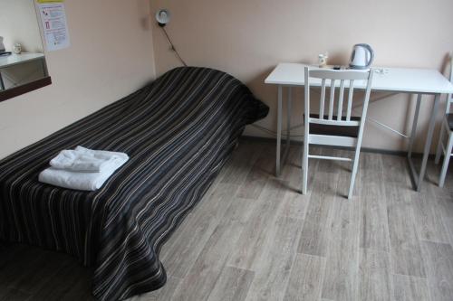 a room with a bed and a table and a table and chair at Hotelli Anna Kern in Imatra