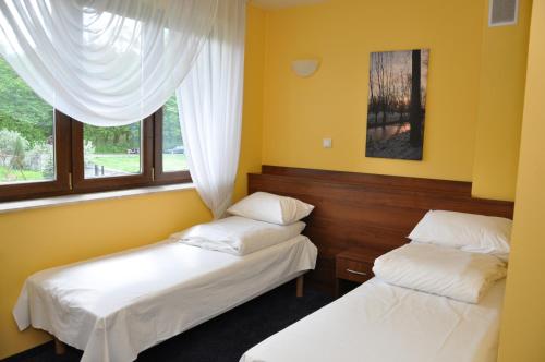- 2 lits dans une chambre avec 2 fenêtres dans l'établissement Markiz Łopuszno, à Łopuszno