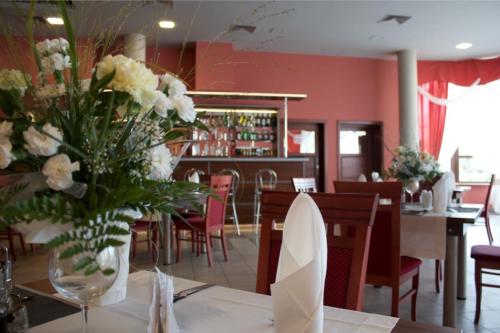 une salle à manger avec une table et un vase de fleurs dans l'établissement Markiz Łopuszno, à Łopuszno