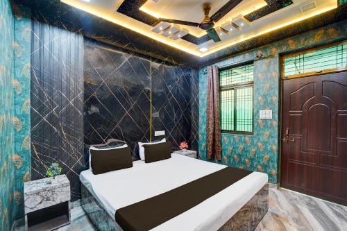 a bedroom with a large bed and a wooden door at Hotel O Royal Prayag in Prayagraj