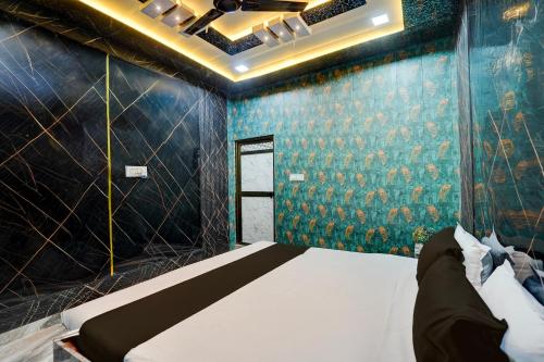 a bedroom with a bed and a blue wall at Hotel O Royal Prayag in Prayagraj