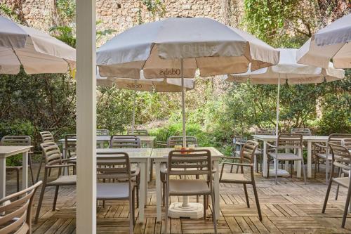 a group of tables and chairs with umbrellas at Appart'hôtel Odalys City - Monaco Les Hauts de la Principauté in Beausoleil