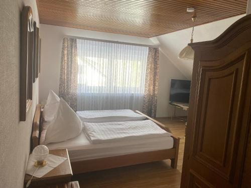 a small bedroom with a bed and a window at Gästehaus Wildfein in Wilnsdorf