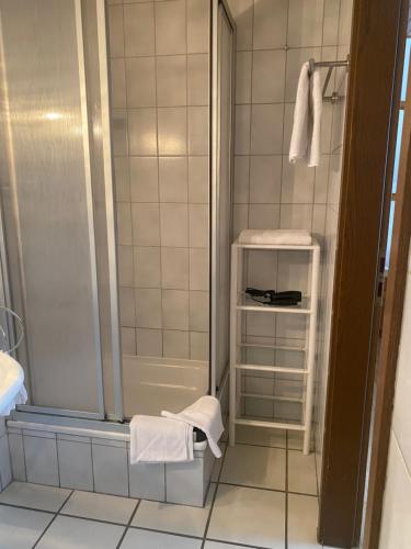 a bathroom with a shower and a toilet and towels at Gästehaus Wildfein in Wilnsdorf