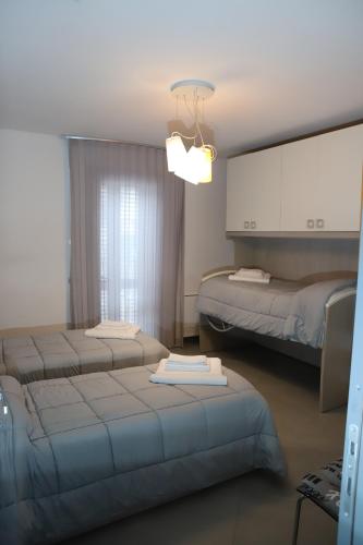 a hotel room with three beds and a chandelier at Mandrolisai Rooms in Samughèo