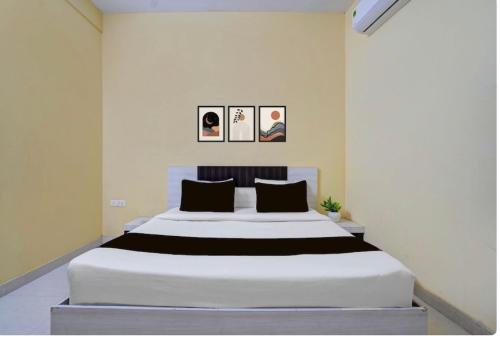 a bedroom with a large white bed with three pictures on the wall at Hotel Sri Krishna palace in Kātni