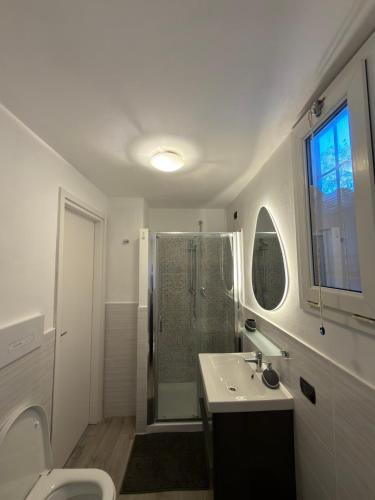 ein weißes Badezimmer mit Dusche und Waschbecken in der Unterkunft Gerenzone Bridge-Air conditioning in Lecco