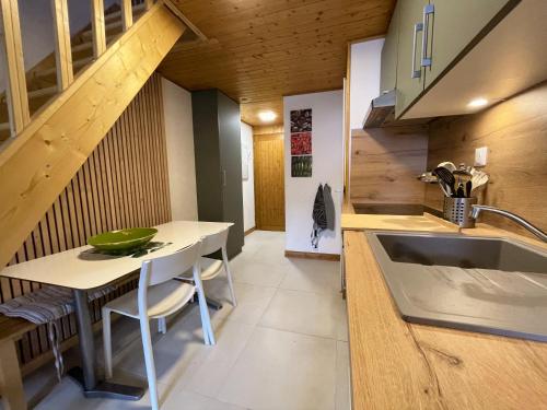 a kitchen with a table and a sink and a staircase at Between lake en ski resort in Thollon