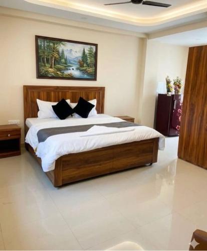 a bedroom with a large wooden bed with black pillows at Super Townhouse HOTEL SPR ROAD in Gurgaon