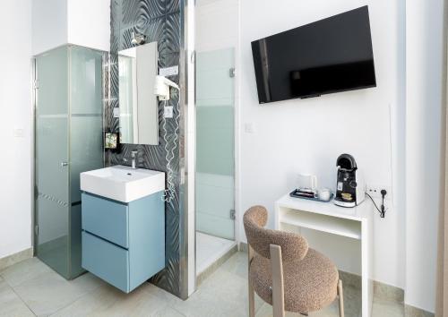 a bathroom with a sink and a mirror and a chair at Nest Style Granada in Granada