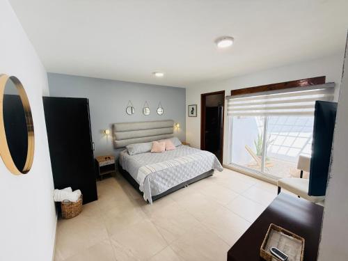a bedroom with a bed and a large window at Casa Ejecutiva Acogedora Impecable AGS in Aguascalientes