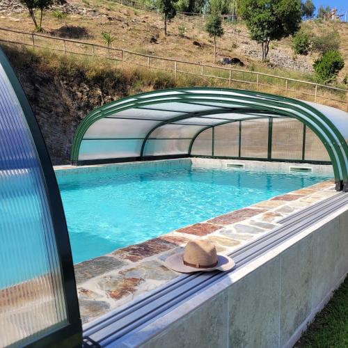 a hat sitting on the edge of a swimming pool at Quinta da Xistosa in Foz do Sousa