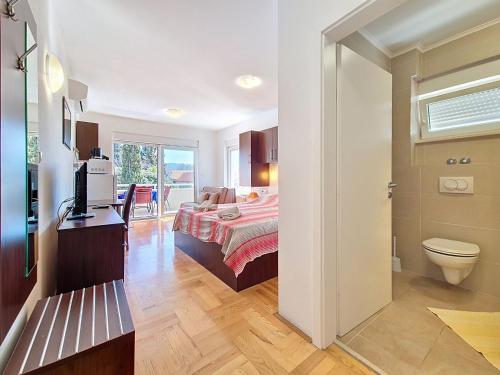 a bedroom with a bed and a toilet in a room at Studio Rilić-2 by Interhome in Zaostrog