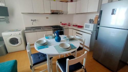 a small kitchen with a table and a refrigerator at BILOCALE IN PIAZZA A NUMANA VISTA MARE BELLISSIMA - cod 485 in Numana