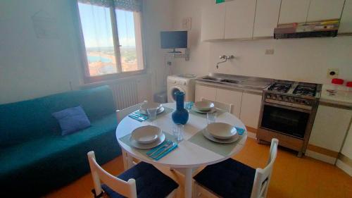 a small kitchen with a white table and chairs at BILOCALE IN PIAZZA A NUMANA VISTA MARE BELLISSIMA - cod 485 in Numana