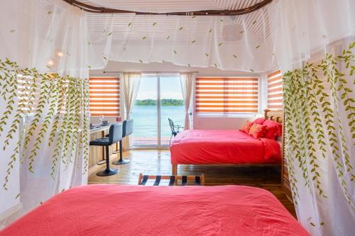 two beds in a room with a view of the water at Coral Wing Casitas in Bastimentos