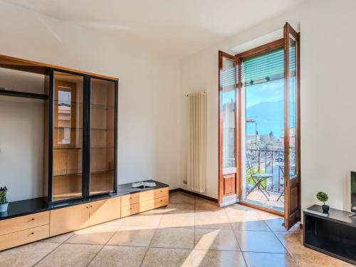 an empty room with glass doors and a balcony at Apartment Casa Luvit by Interhome in Menaggio